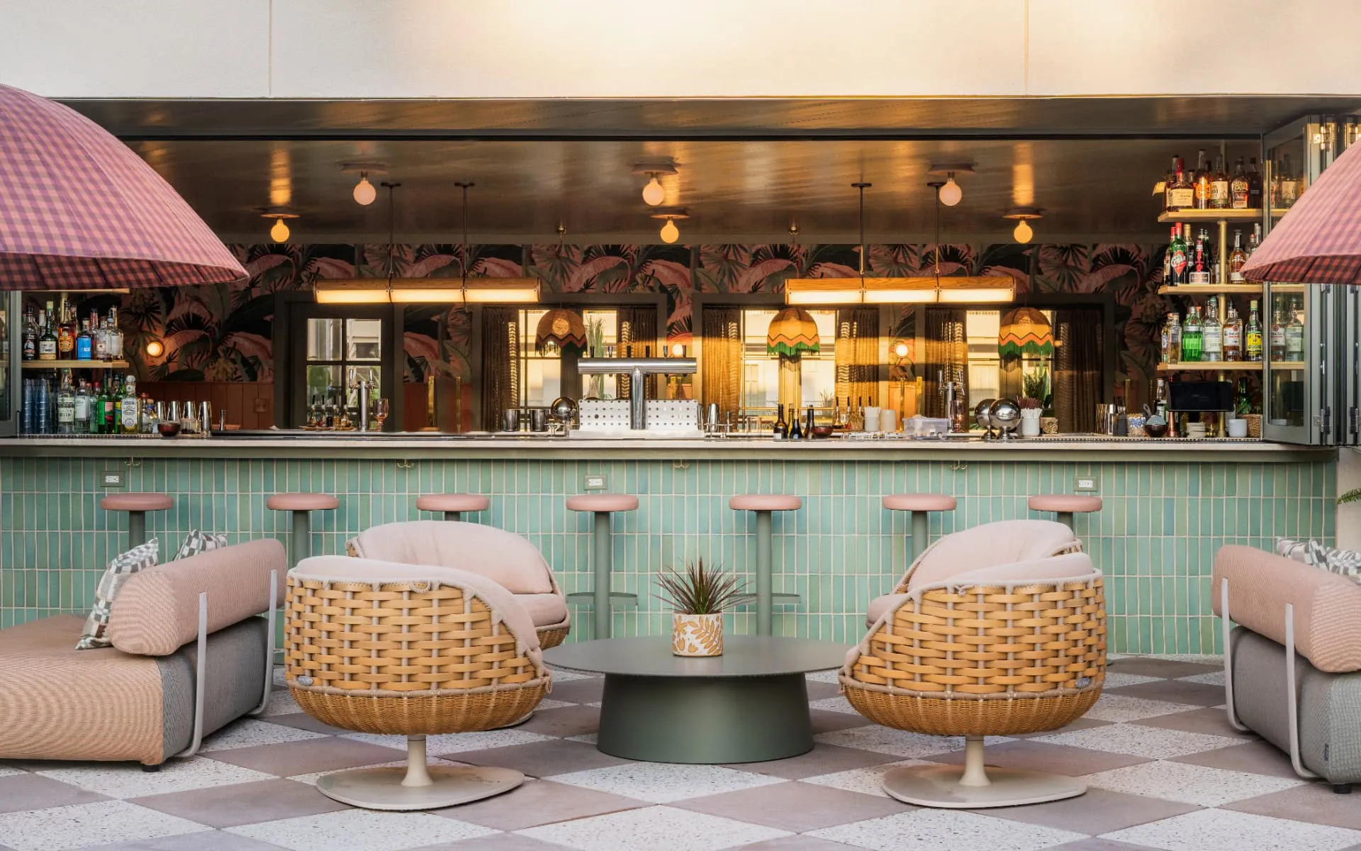 Sunlit hotel bar with woven armchairs and green tile