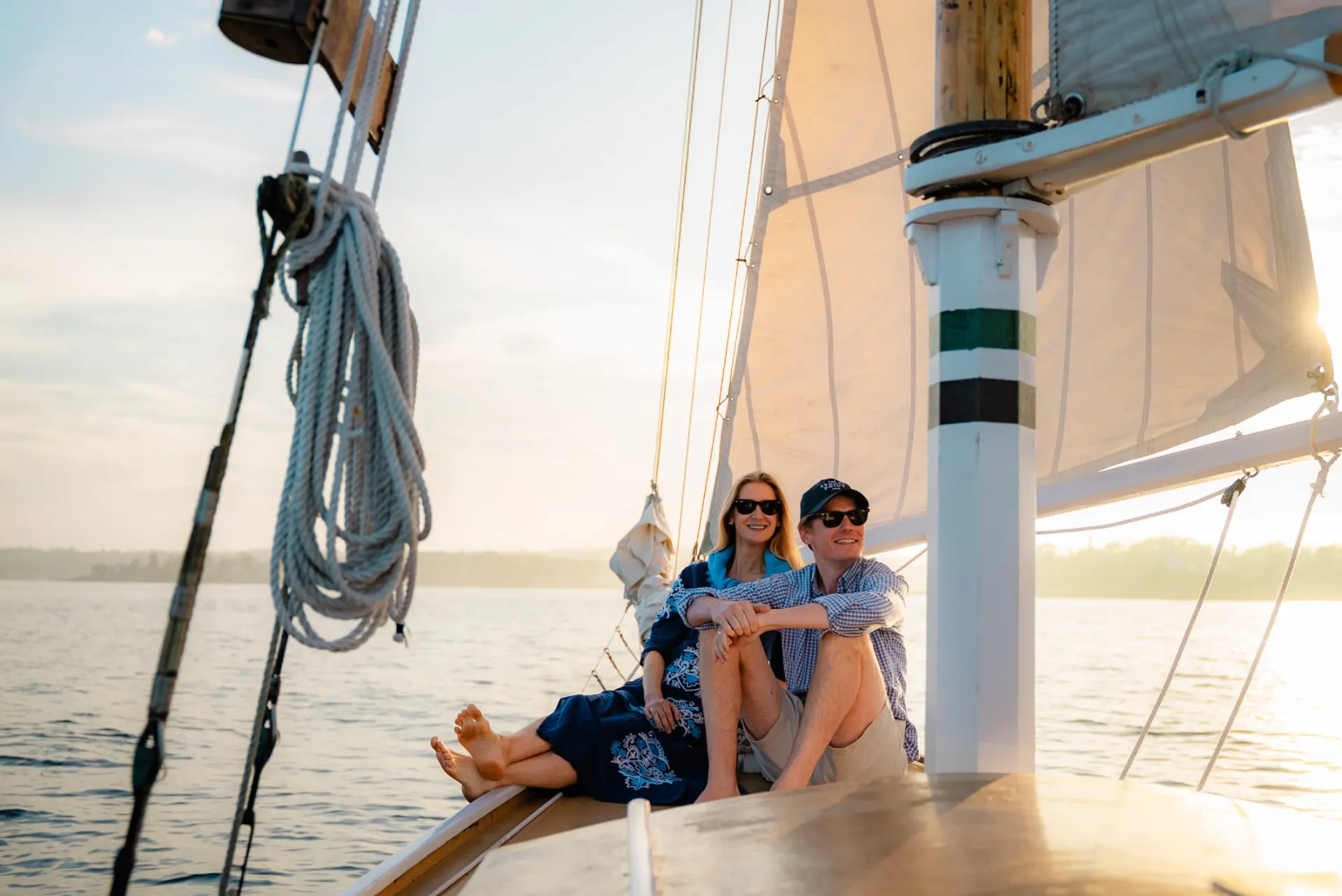 Couple on the bow of a sailboat at golden hour
