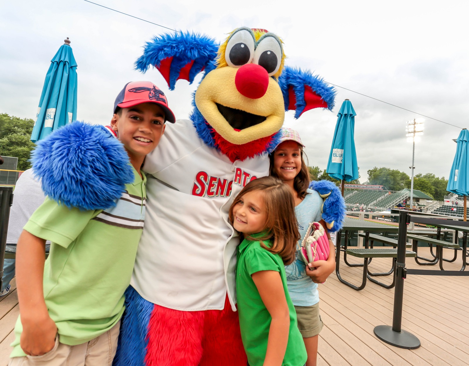 Kids hugging the Harrisburg Senators mascot at the ballpark