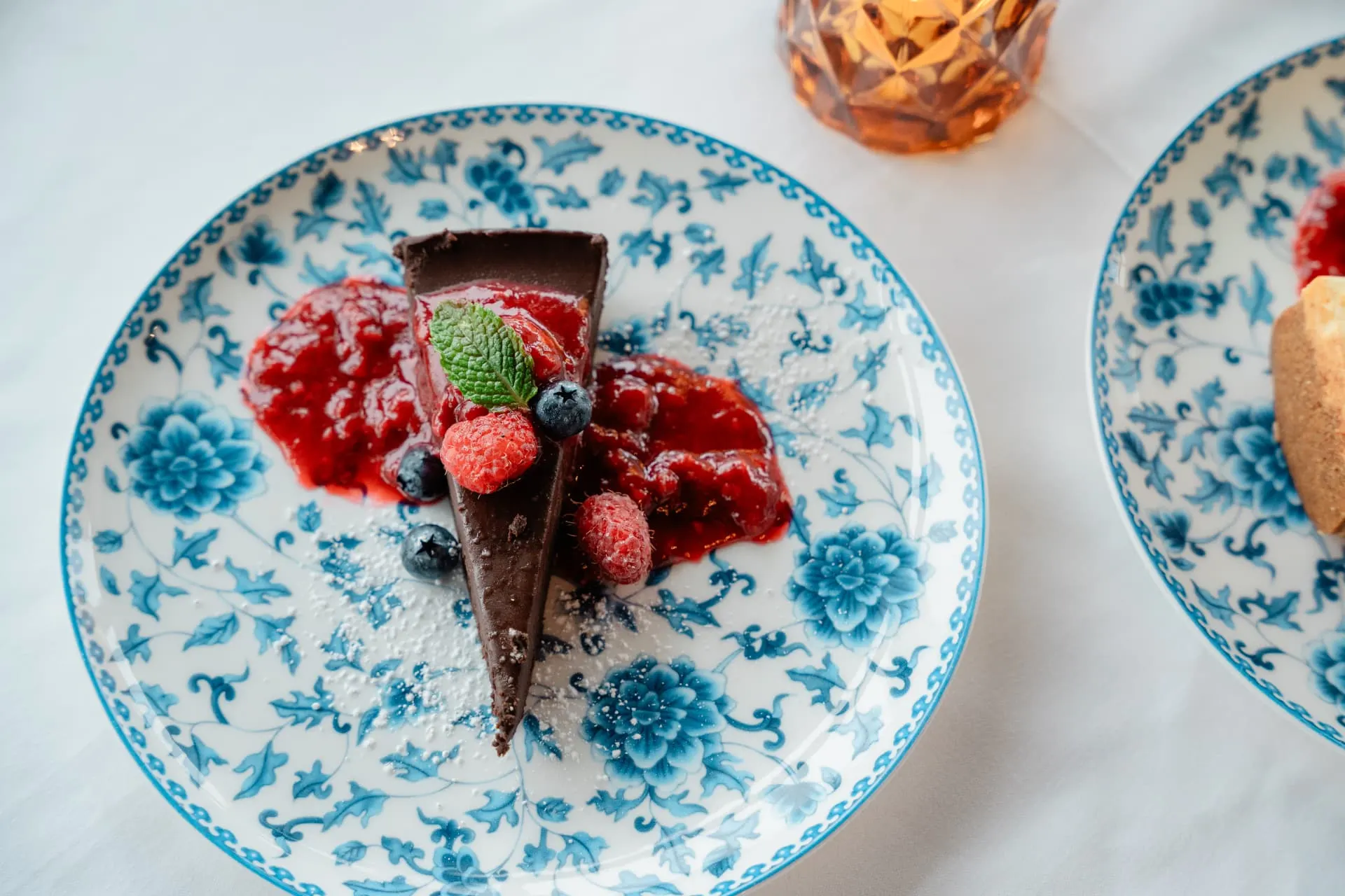 Chocolate tart with berries on blue-and-white china